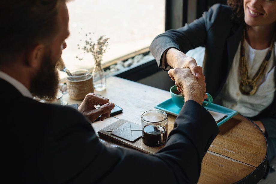 Two professionals shake hands after a meeting