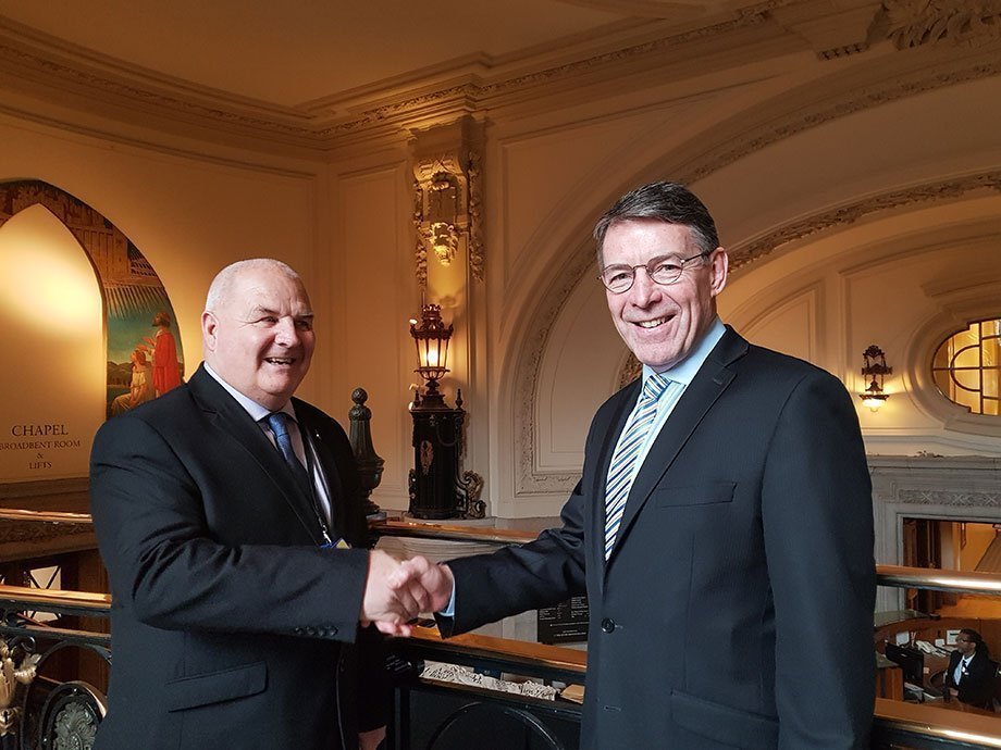 Two men shaking hands inside Central Hall Westminster